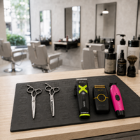 Alfombrilla protectora de silicona L3VEL3 en mesa de peluquería con máquinas de corte y tijeras