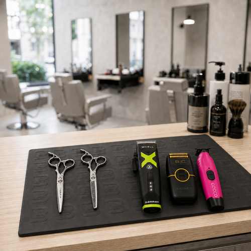 Alfombrilla protectora de silicona L3VEL3 en mesa de peluquería con máquinas de corte y tijeras