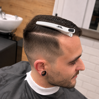 Uso de pinza de corte JRL sujetando el cabello superior durante un corte de pelo degradado